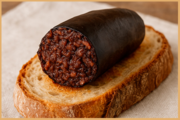 morcilla de calabaza tradicional servida sobre rebanada de pan rústico con fondo de lino beige min