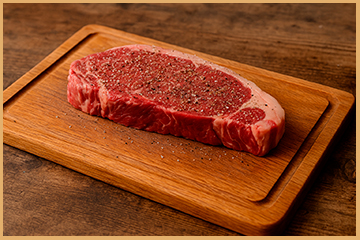 entrecot de ternera Gombao sazonado con sal y pimienta sobre tabla de cocina