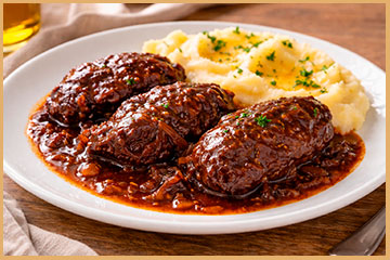 Carrilleras de cerdo guisadas al vino tinto servidas con salsa